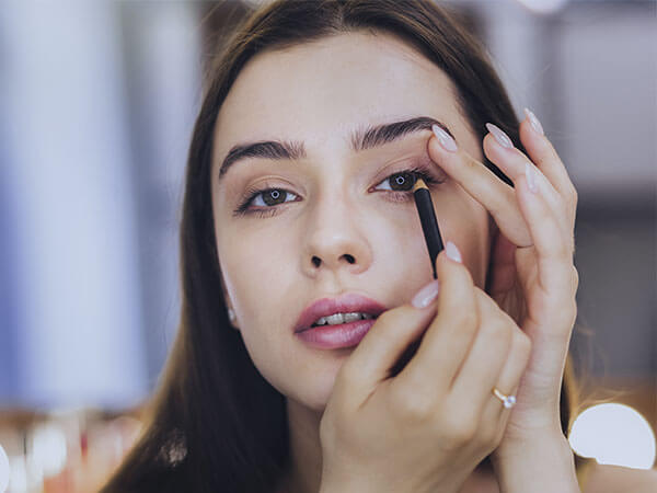 Mujer pintándose la raya del ojo